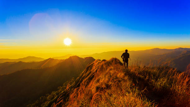 istock silhouette man on top of mountain against sunset 697875150