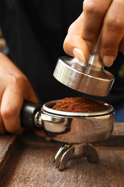 istock Freshly ground coffee beans in a metal filter on hand 697882556