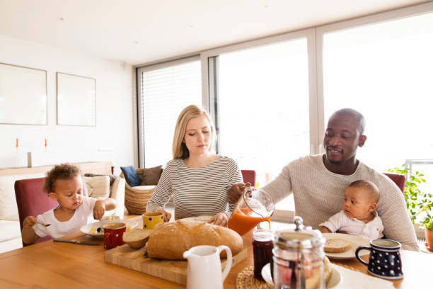 istock Young interracial family with little children having breakfast. 697886582