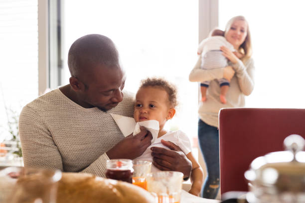 istock Young interracial family with little children having breakfast. 697886680