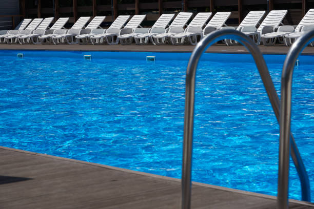 istock Beautiful pool with blue water under the open sky. The image is focused on beach chairs 697895308