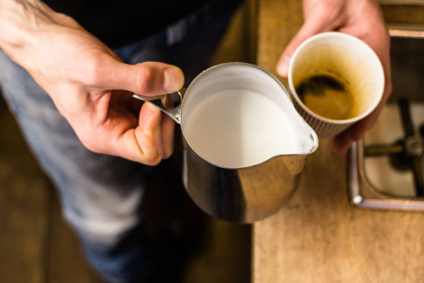 istock Barista preparing to add milk for takeaway coffee. 697901036