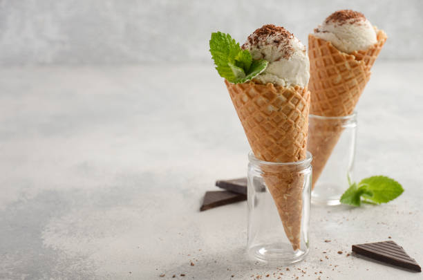 istock Vanilla ice cream in waffle cone on grey concrete background 697905936