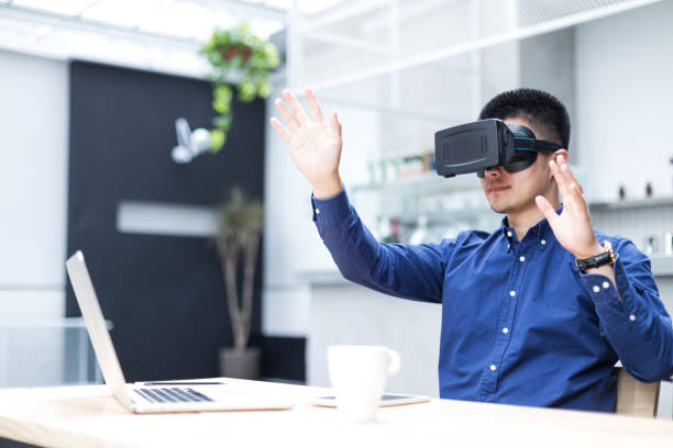 istock young asian man with VR in modern cafe 697906036