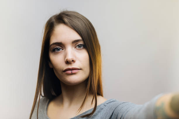istock Young woman talking selfie against gray background. 697909234