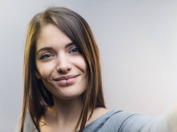 istock Beautiful woman talking selfie against gray background. 697909278