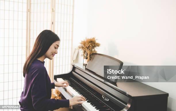 Muy Hermosa Asiática Joven Sentado En El Piano Foto de stock y más banco de imágenes de Piano - Piano, Mujeres, Jugar