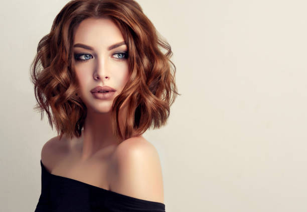 Attractive brunette woman with modern, trendy and elegant hairstyle. Attractive brown haired  woman  with modern, trendy and elegant hairstyle. Example of middle length,dense and curly hair.Gentle make up and long eyelashes. fashion and beauty stock pictures, royalty-free photos & images