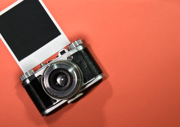 istock blank instant photo frame on red background highlighted with old retro vintage camera and copy space 697916274