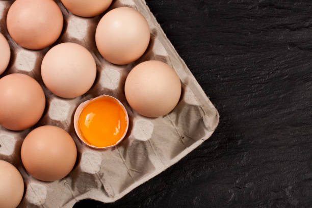 istock eggs in a tray on a dark background with copy space for your text. Top view 697916822