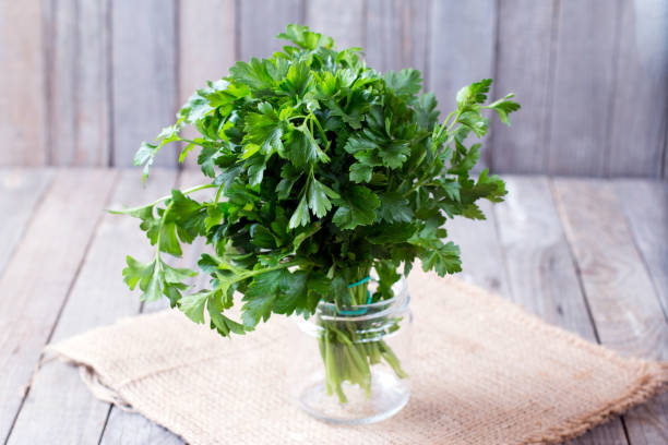 prezzemolo verde fresco sul tavolo di legno - parsley spice herb garnish foto e immagini stock