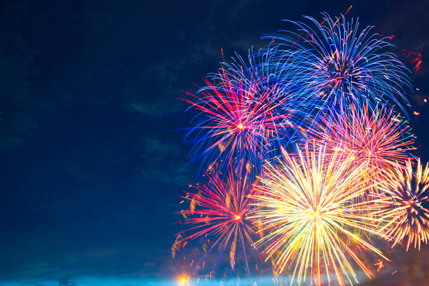 Fireworks of various colors bursting against a black