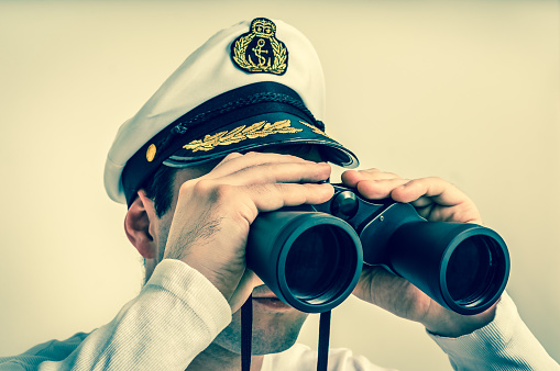Captain looks through a binoculars - marine concept