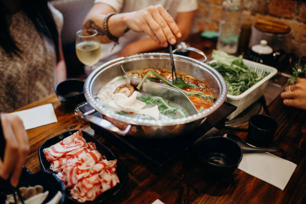 istock Korean hot pot meal. Hands taking food with chopsticks. 697932402