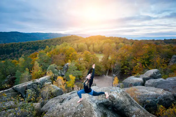 Photo of Sporty fit woman is practicing yoga on the top of the mountain