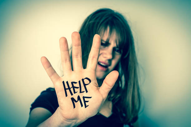 istock Woman covers her face and showing message help me 697933240