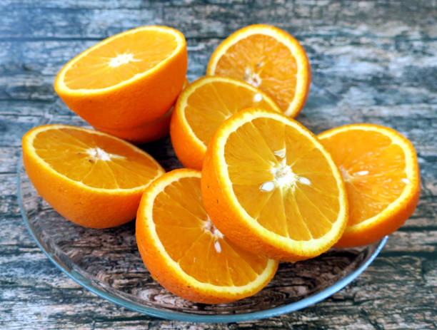istock Half cut oranges on wooden background 697939866