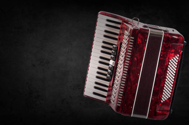 istock Red accordion on wooden grey background. Write text 697946138