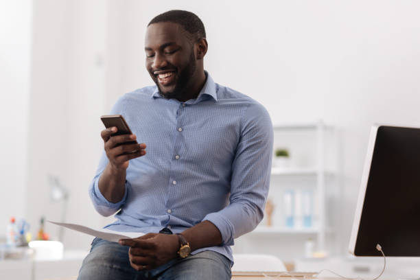 istock Cheerful pleasant man holding his smartphone 697950014