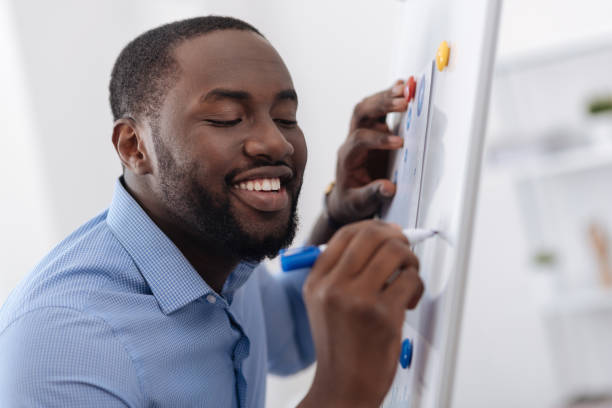 istock Joyful pleasant man drawing on the whiteboard 697950588