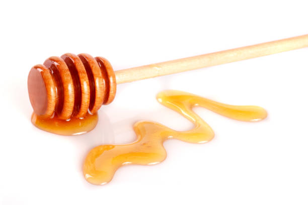 istock Honey stick with flowing honey isolated on white background 697952894