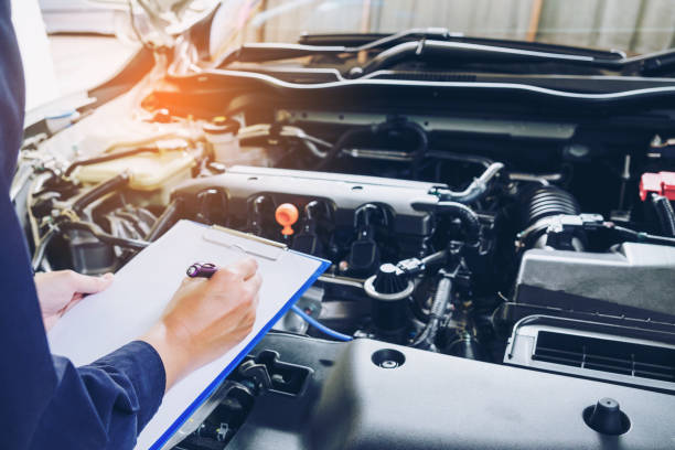 Mechanic man holding clipboard and check the car