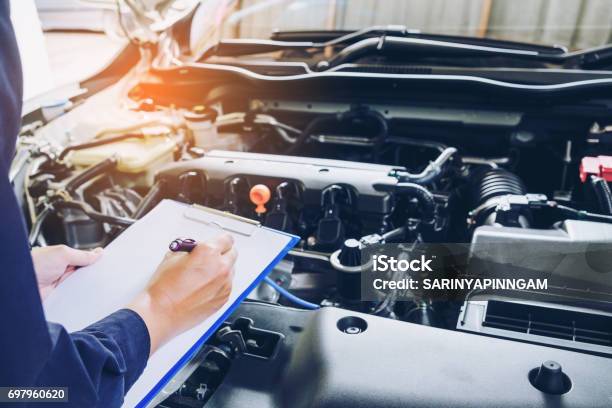 Mechanic Man Holding Clipboard And Check The Car Stock Photo - Download Image Now - Auto Repair Shop, Car, Auto Mechanic