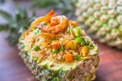 Close up Thai pineapple fried rice with shrimp, chicken meat and vegetables slices.