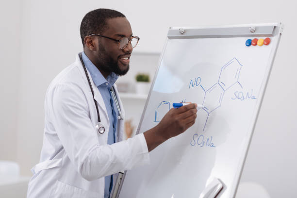 istock Smart cheerful scientist writing on the whiteboard 697961066