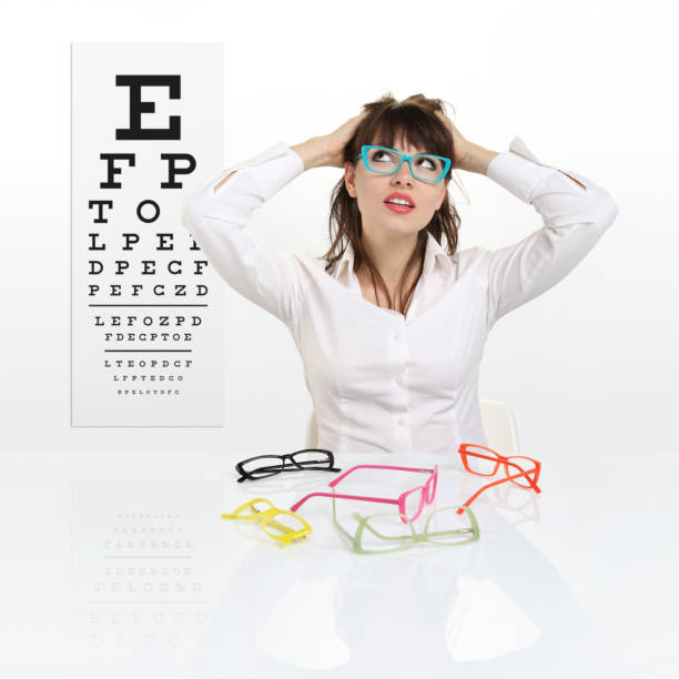 istock smile female face chooses spectacles on eyesight test chart background, eye examination ophthalmology concept 697961256