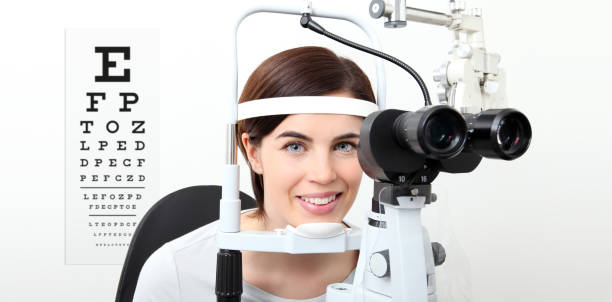 mujer de sonrisa haciendo medición de vista con lámpara de hendidura y la carta de test visual en blanco - doctor reading chart human eye fotografías e imágenes de stock