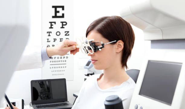 istock woman doing eyesight measurement with trial frame and visual test chart on white 697961272