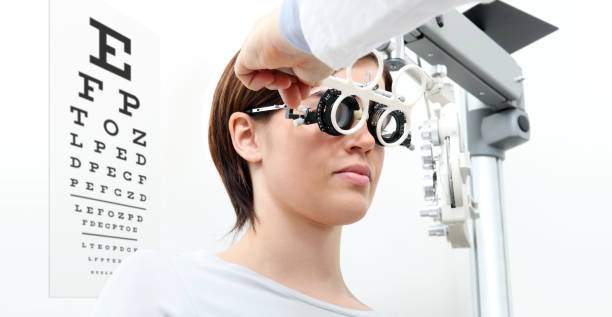 mujer haciendo medición de vista con marco de ensayo y prueba visual gráfico en blanco - doctor reading chart human eye fotografías e imágenes de stock