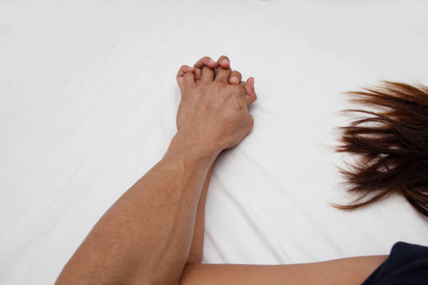 A hairy man's hand holding a woman hand for rape and sexual abuse concept stock photo