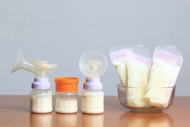 flaschen und gefrorenen brust milch aufbewahrungsbeutel für neues baby auf holztisch - human nipple fotos stock-fotos und bilder