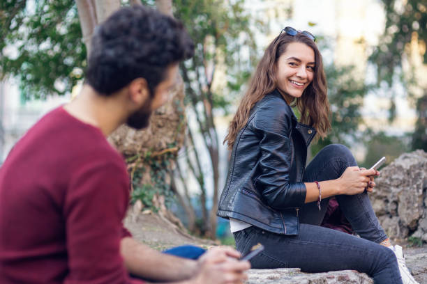 istock Girl smiling at a boy in the park 697982918