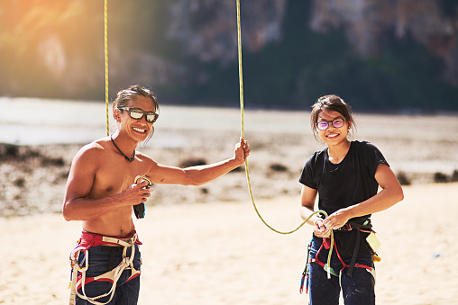 Portrait of two rock climbers adjusting their harnesses