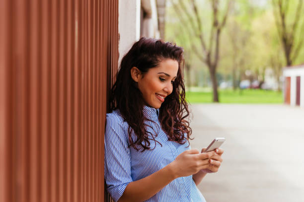 istock Cute girl standing next to wall and texting 698005294