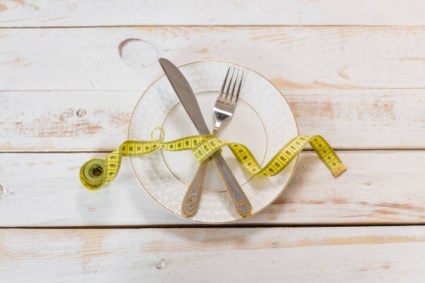 istock measuring tape on a wooden background. diet concept 698005430