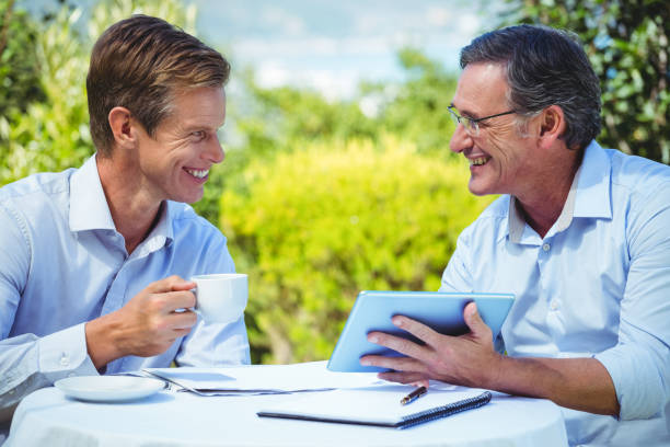 istock Two businessmen meeting in a restaurant using tablet 698006124