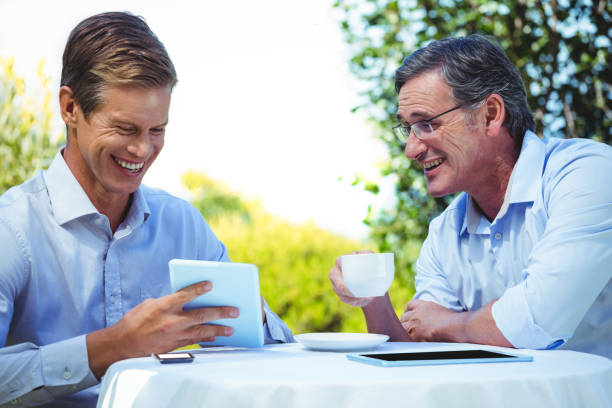 istock Two businessmen meeting in a restaurant using tablet 698006208