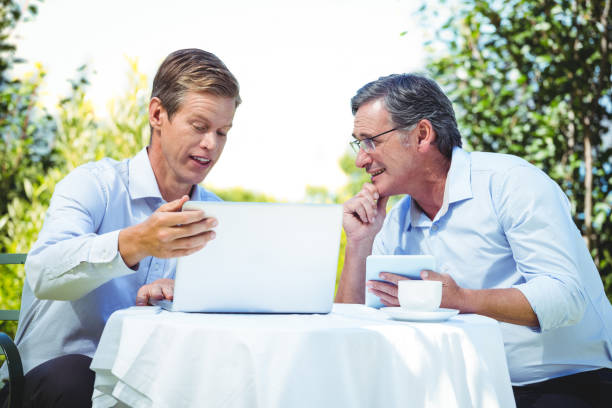 istock Two businessmen meeting in a restaurant using laptop 698006310