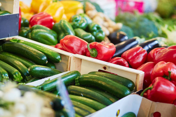 frische bio paprika und zuccinis am bauernmarkt - green bell pepper bell pepper red bell pepper groceries stock-fotos und bilder