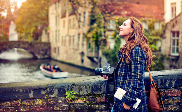 Tourist in Bruges Young woman with a camera enjoying travel to Bruges, Belgium fall travel stock pictures, royalty-free photos & images