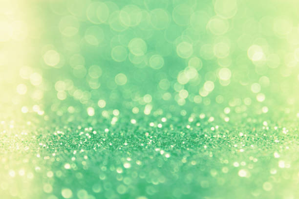istock Green glitter abstract background with bokeh defocused lights 698022774