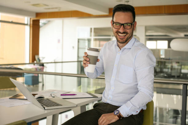 istock Business man in office having a break. Man with cup of coffee looking at camera. 698022986