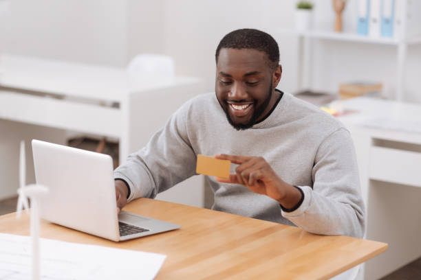istock Positive happy man holding a credit card 698023008