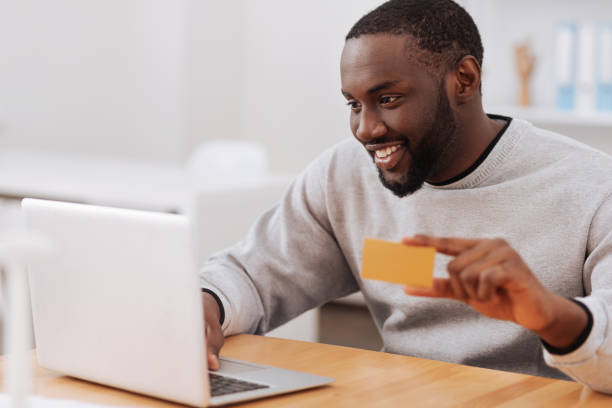 istock Cheerful pleasant man making an online payment 698023088
