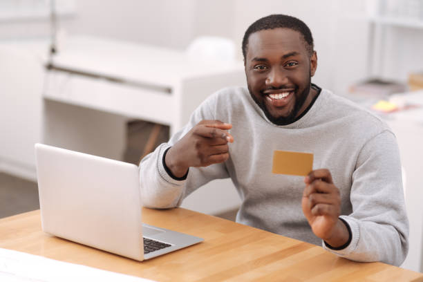 istock Handsome delighted man pointing at the credit card 698023210