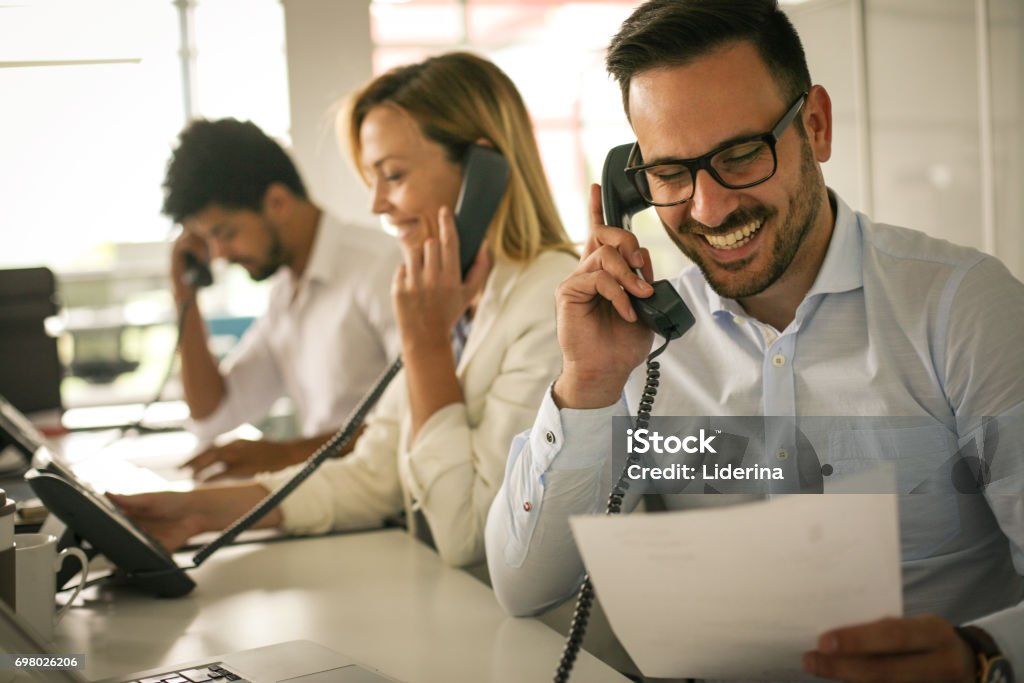 People in operations center  talking on Landline phone. Operators in the office. Telephone Stock Photo